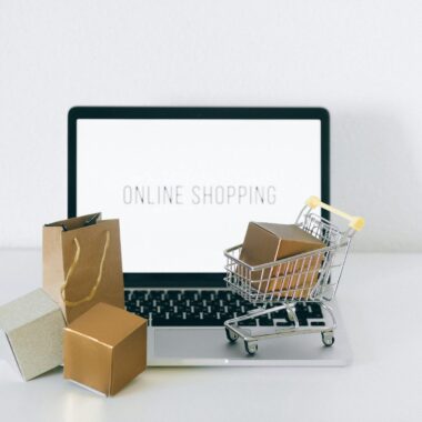 Laptop displaying online shopping with boxes and cart, representing ecommerce.