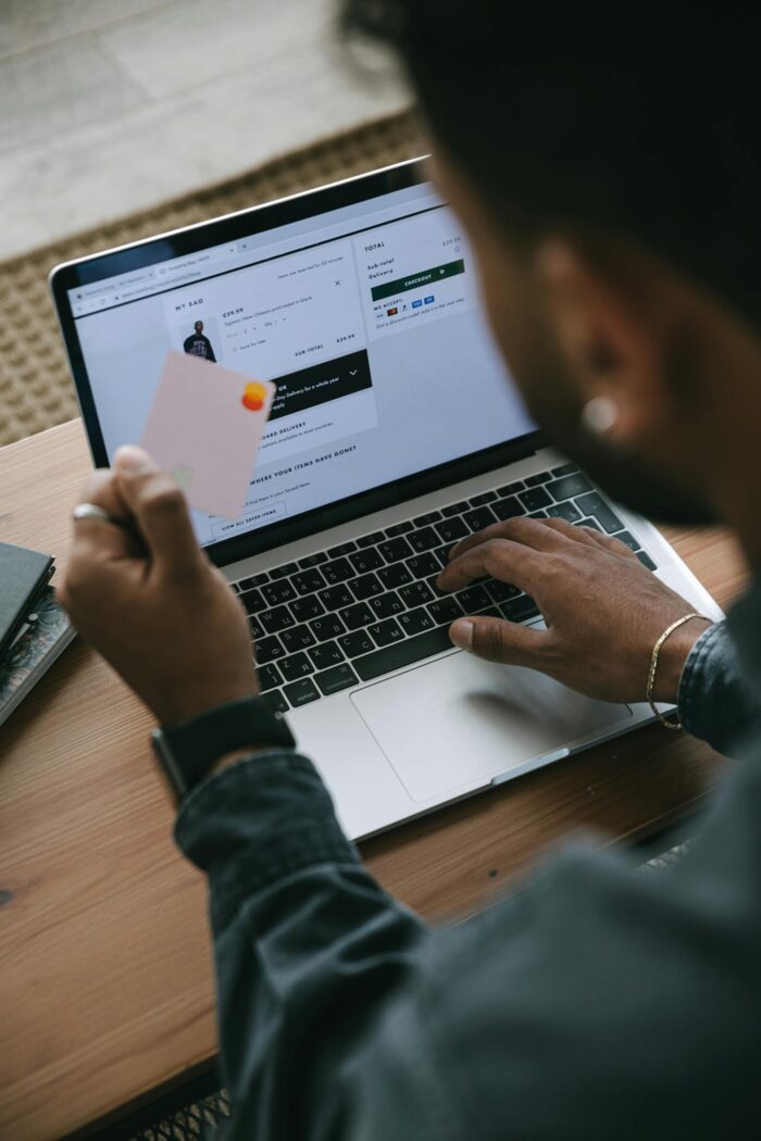 Person shopping online using a laptop and credit card.